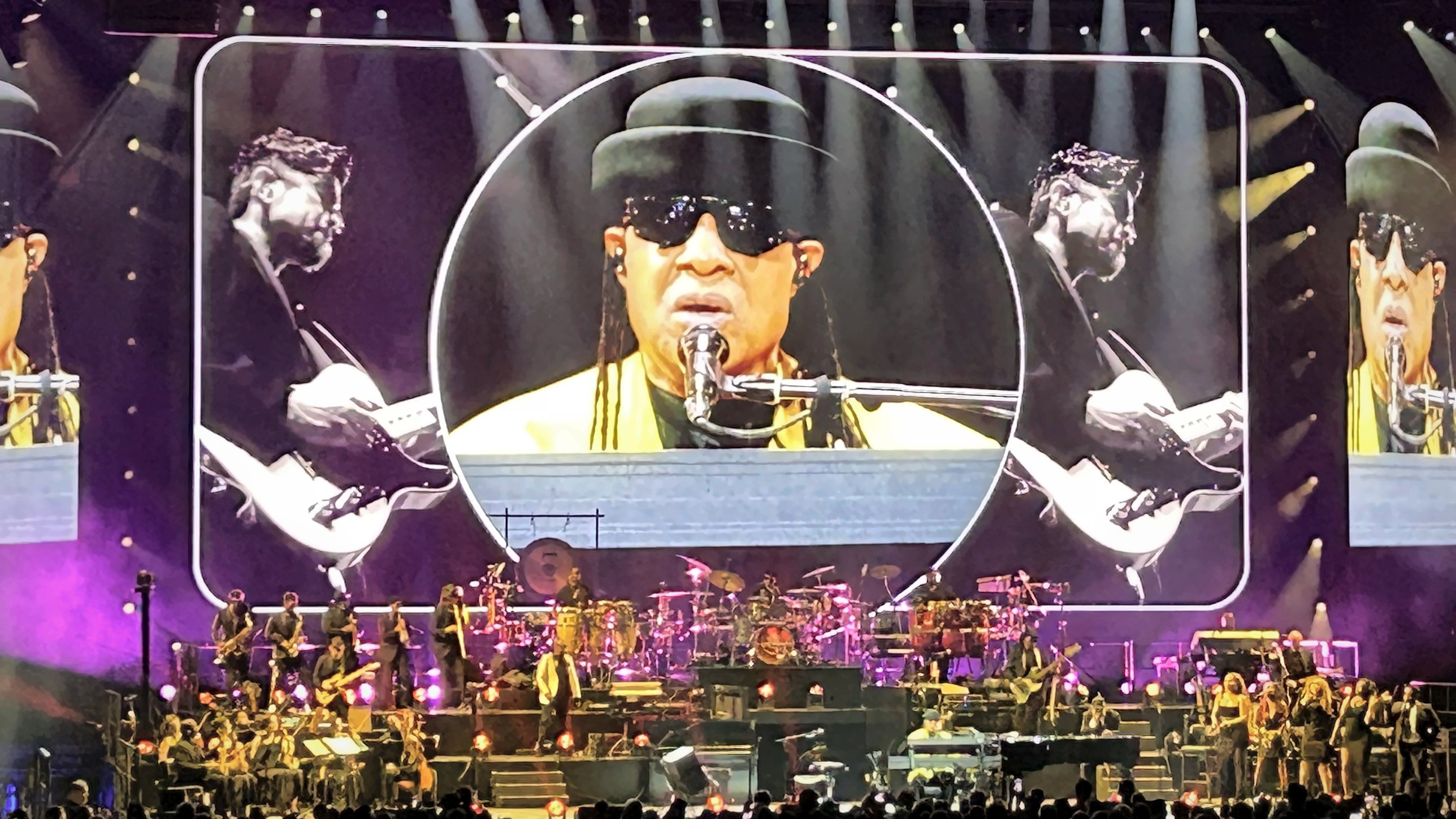 The stage of the Lanxess Arena in Cologne, with Stevie Wonder shown in a circle on the giant screen above his band